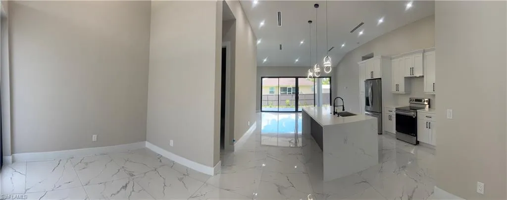 Open-concept living space featuring high ceilings, recessed lighting, and large format marble-look tile flooring