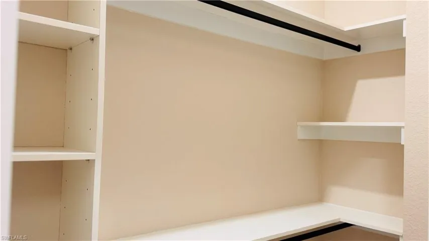 Integrated shelving system with adjustable shelves, a corner hanging rod, and additional floating shelving