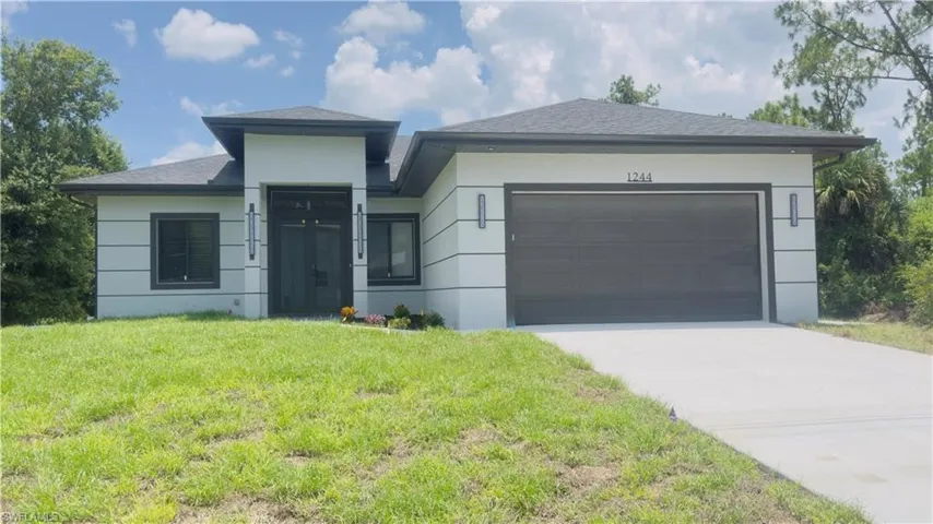 Modern architectural home featuring a grey shingle roof, light-colored stucco exterior with horizontal accents, and a dark grey garage door