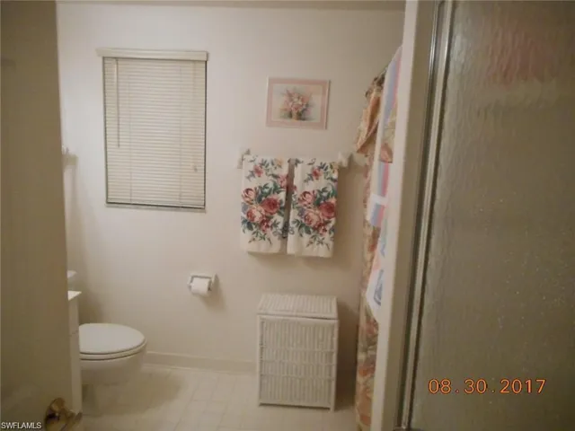 Bathroom featuring a shower with shower curtain and baseboards