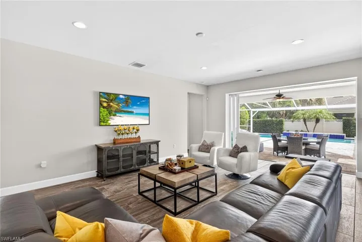 Living room featuring a sunroom, recessed lighting, a ceiling fan, and wood finished floors