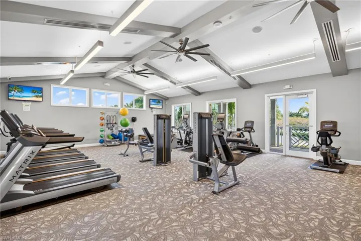 Gym featuring beam ceiling and a ceiling fan