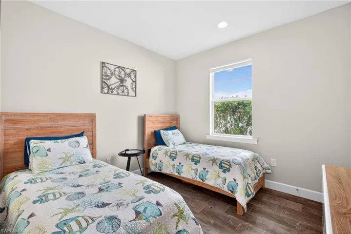 Bedroom with dark wood finished floors and recessed lighting
