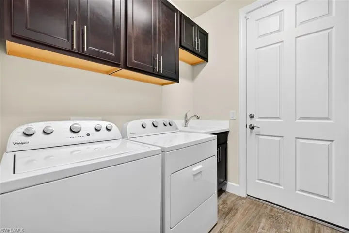 Laundry area featuring cabinet space, separate washer and dryer, and light wood finished floors