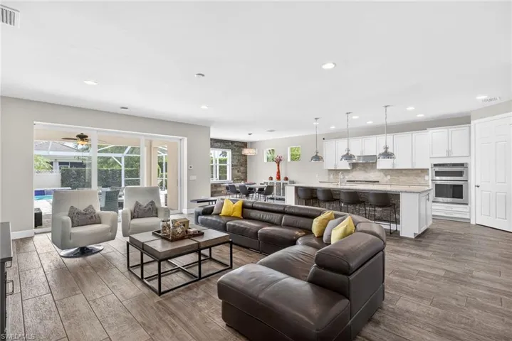 Living room with dark wood-style flooring, recessed lighting, and ceiling fan