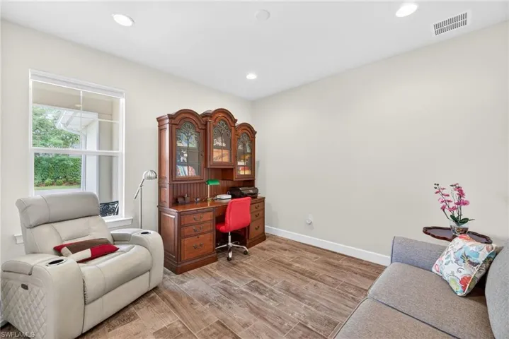 Den featuring wood finish floors and recessed lighting