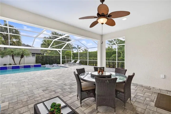 View of patio / terrace with a lanai, a sunroom, outdoor dining space, and ceiling fan