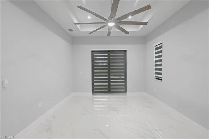 Unfurnished room with a ceiling fan, recessed lighting, and marble finish flooring
