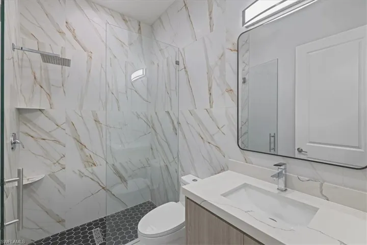 Full bath with vanity and a marble finish shower