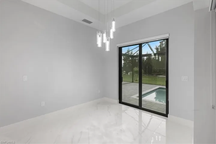 Unfurnished room featuring marble tiled flooring and a chandelier
