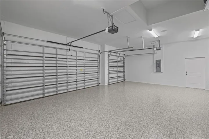 Garage featuring electric panel and a garage door opener