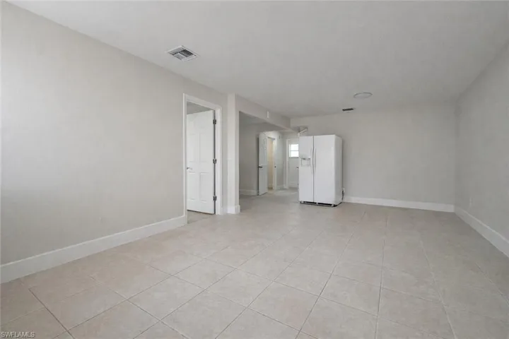 Empty room with baseboards and light tile patterned flooring
