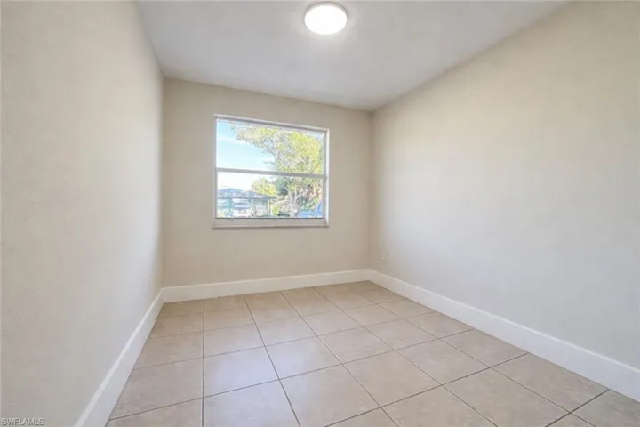 Spare room featuring baseboards and light tile patterned floors