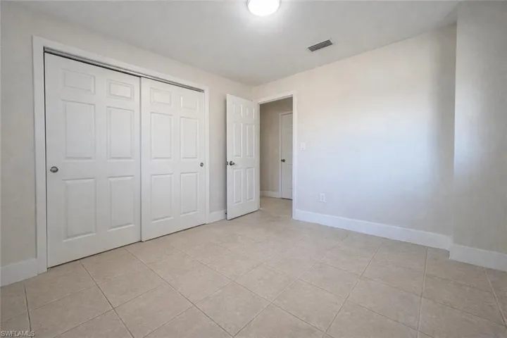 Unfurnished bedroom featuring light tile patterned floors and a closet