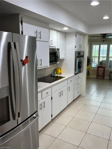 Kitchen featuring white cabinetry, stainless steel appliances, a built-in oven, and a ceramic tile floor