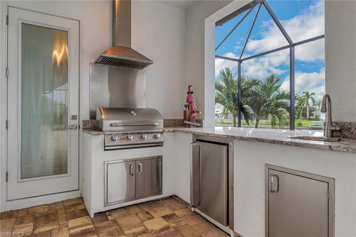 Vented summer kitchen w/ stainless appliances. Glass door access pool bath.