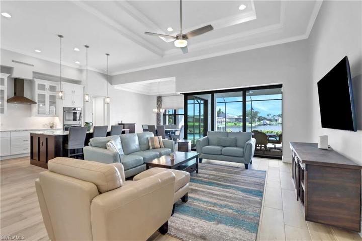 Living room w/ double trey ceilings, crown molding, and wooden plank tiled floors.