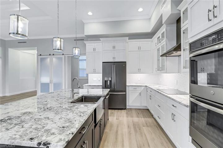Level 5 granite counters, two toned custom cabinets (notice the drawers!), induction cook top, double wall ovens, stainless farm sink, crown molding, tiled backsplash.