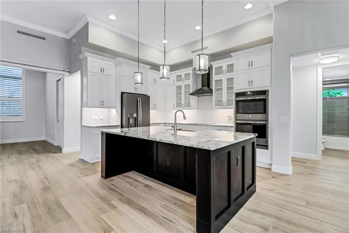Level 5 granite counters, two toned custom cabinets, under cabinet lighting, induction cook top, double wall ovens, pendant lighting, crown molding, tiled backsplash. Perfect place for entertaining!