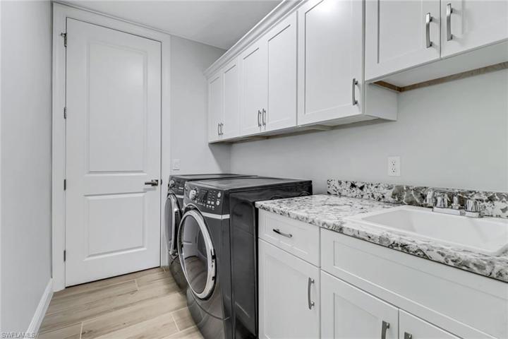 Beautiful laundry room w/ granite counters, custom cabinets and crown molding.
