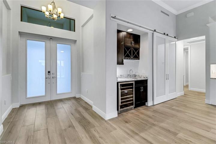 Double front doors (impact glass) transom window, wet bar w/ level 5 granite, and glass barn doors to office (currently covering the office).