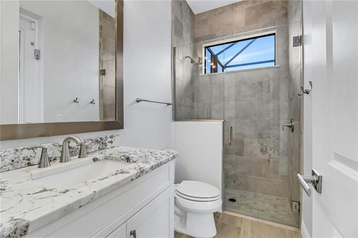 On suite bath w/ frameless glass doors doubles as pool bath w/ access to lanai.