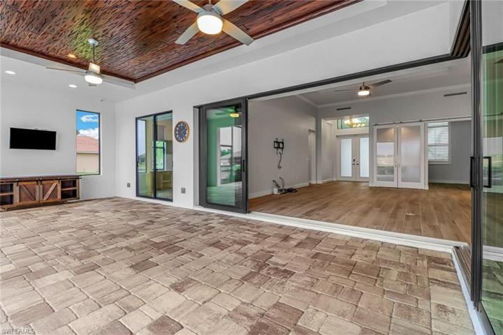 Over sized lanai w/ tongue and groove trey ceiling and 90 degree sling and pocketing glass doors.