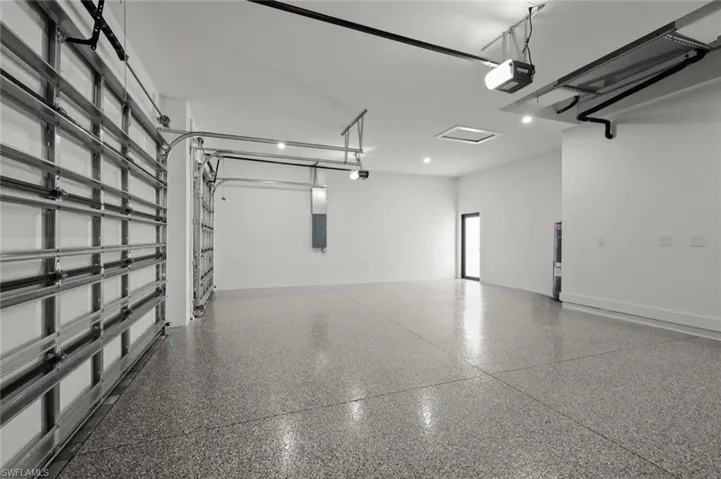 Garage featuring a garage door opener and electric panel
