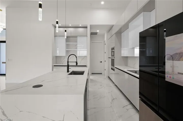 Kitchen featuring modern cabinets, a sink, white cabinets, open shelves, and black refrigerator