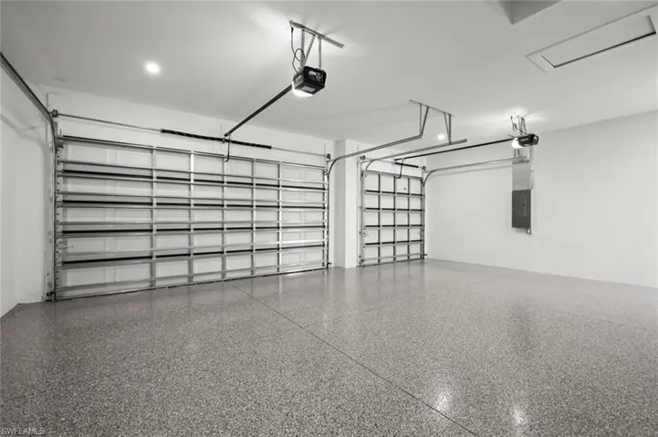 Garage featuring electric panel and a garage door opener