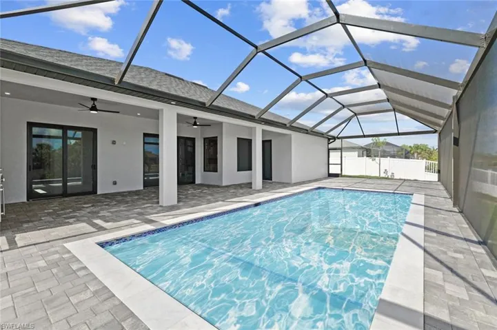 View of pool featuring a ceiling fan, a patio, and glass enclosure