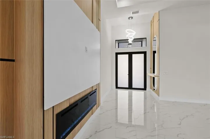 Entrance foyer featuring light marble finish floors and baseboards