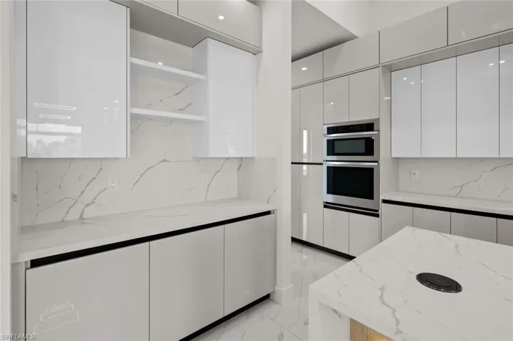 Kitchen featuring open shelves, modern cabinets, light marble finish floors, white cabinets, and backsplash
