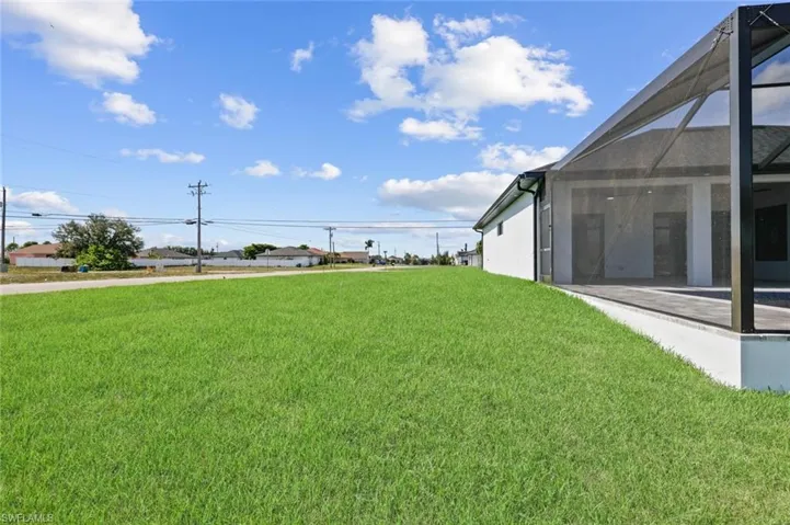 View of green lawn featuring glass enclosure