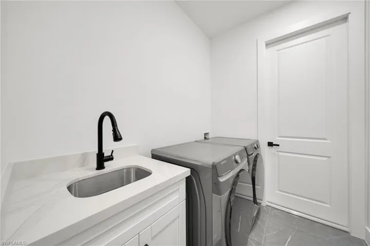 Laundry area featuring separate washer and dryer and cabinet space