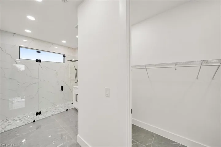 Full bathroom with a walk in closet, a marble finish shower, and recessed lighting