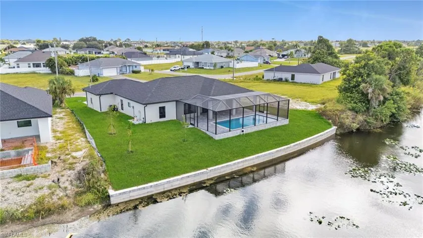 Aerial perspective of suburban area featuring a pool area and a large body of water
