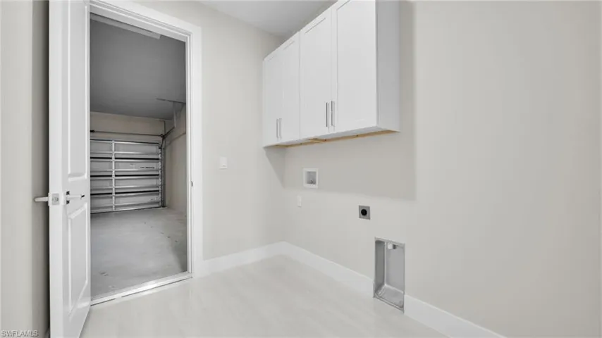 Washroom featuring cabinet space, hookup for an electric dryer, and washer hookup