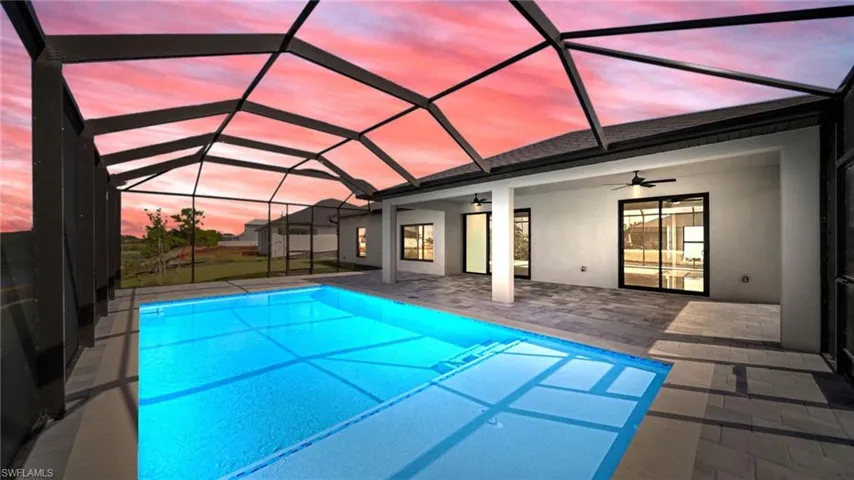 Swimming pool with a sunroom, ceiling fan, glass enclosure, and a patio