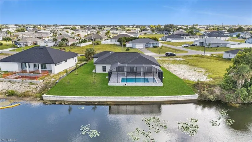 Aerial view of residential area featuring a large body of water and a pool