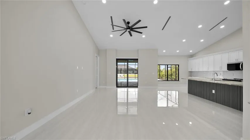 Unfurnished living room featuring recessed lighting, light tile patterned floors, and high vaulted ceiling
