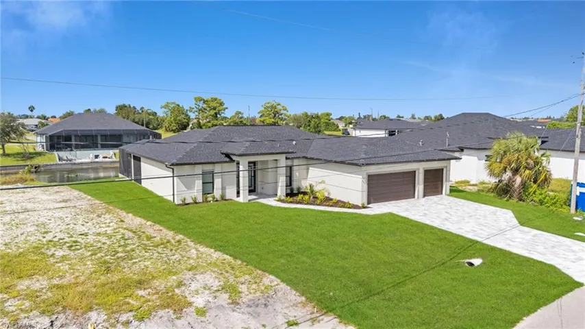 View of front facade featuring decorative driveway, an attached garage, and stucco siding