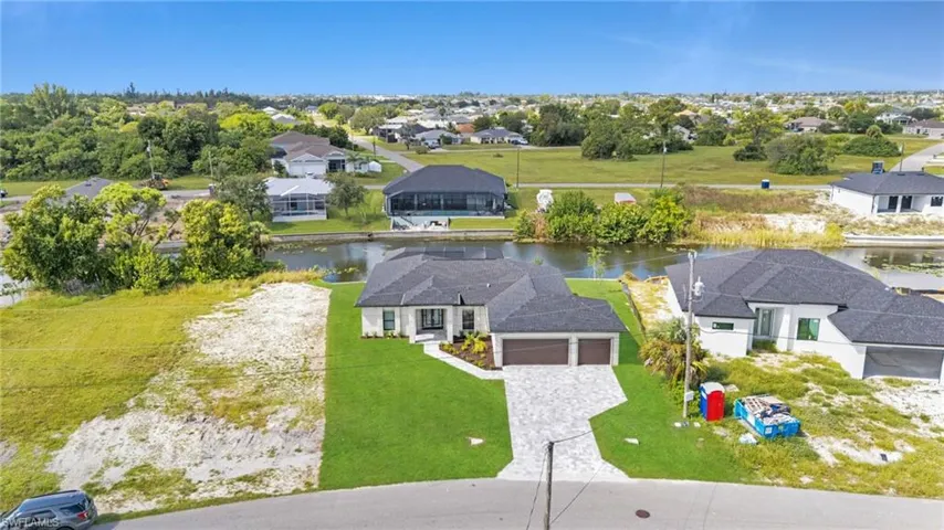 Aerial perspective of suburban area featuring a nearby body of water