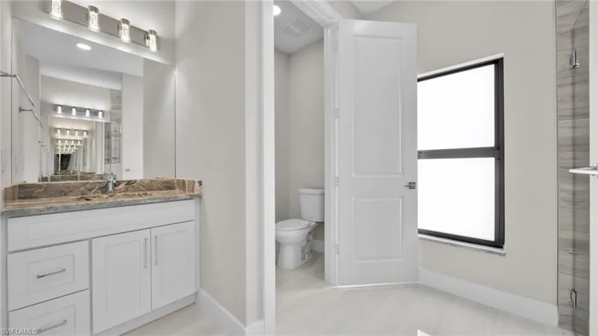 Bathroom with vanity, a shower with door, and recessed lighting