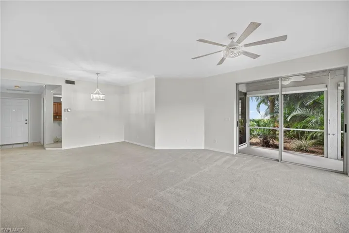 Unfurnished living room with crown molding, light colored carpet, and ceiling fan