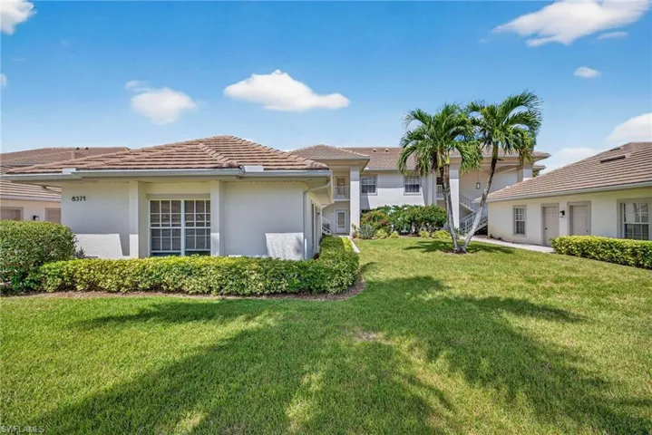 Back of property with stucco siding and a lawn