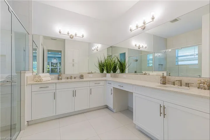 Bathroom featuring a healthy amount of sunlight, double vanity, and tile flooring