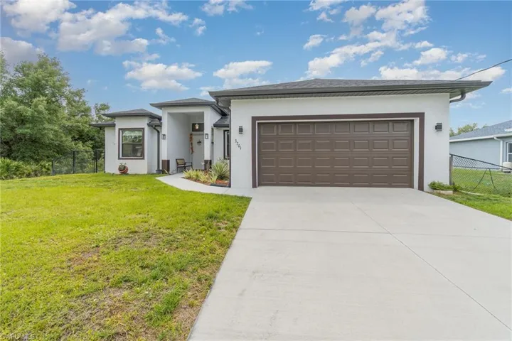 Prairie-style house with an attached garage, stucco siding, and driveway