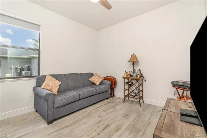 Living area with light wood-style flooring and a ceiling fan