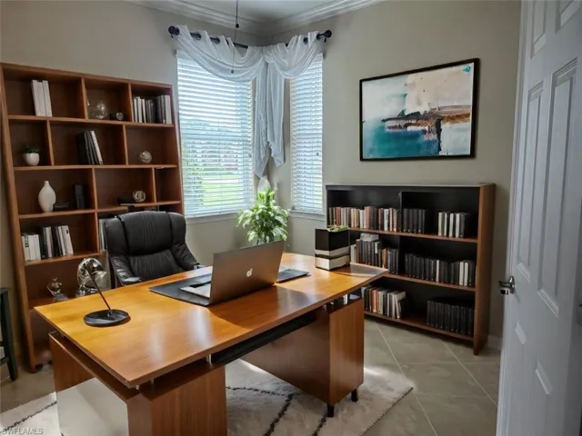 Den virtually staged as a Home office with crown molding and light tile floors